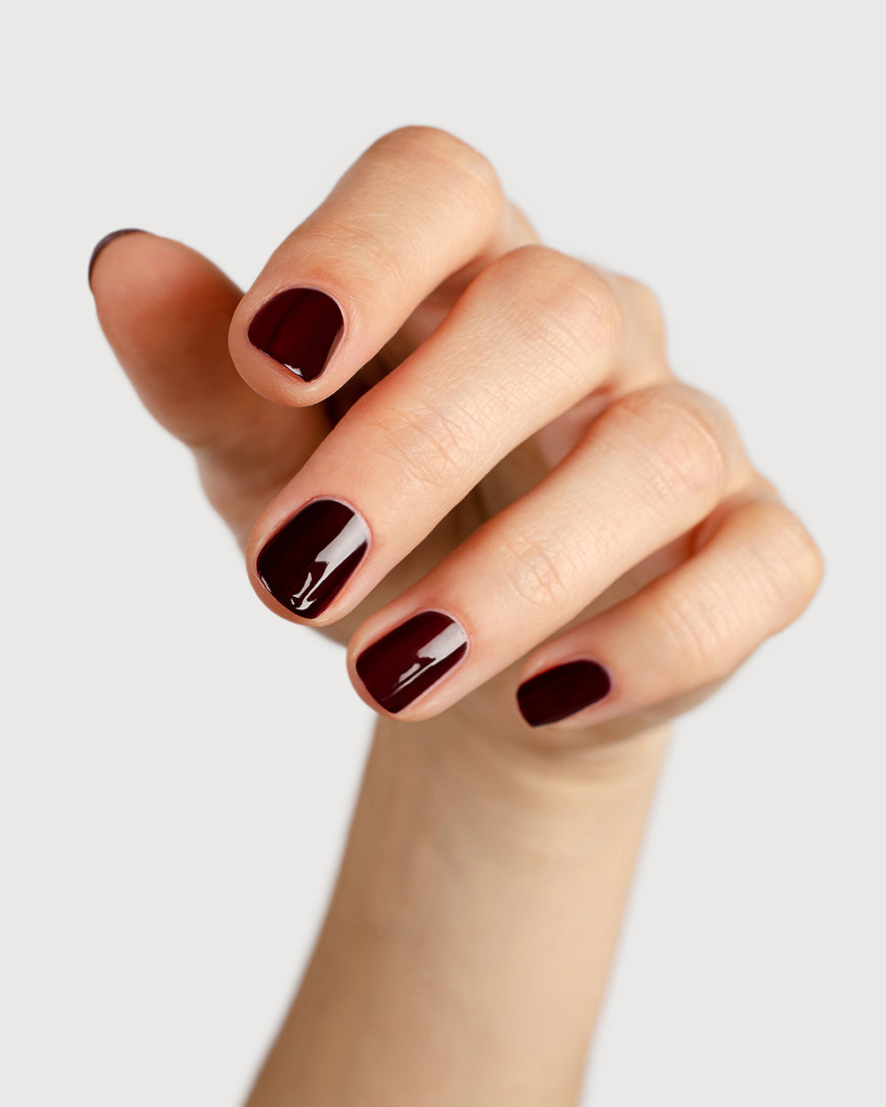 dark red nail polish hand swatch on fair skin tone