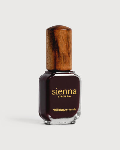 dark red nail polish bottle with timber cap