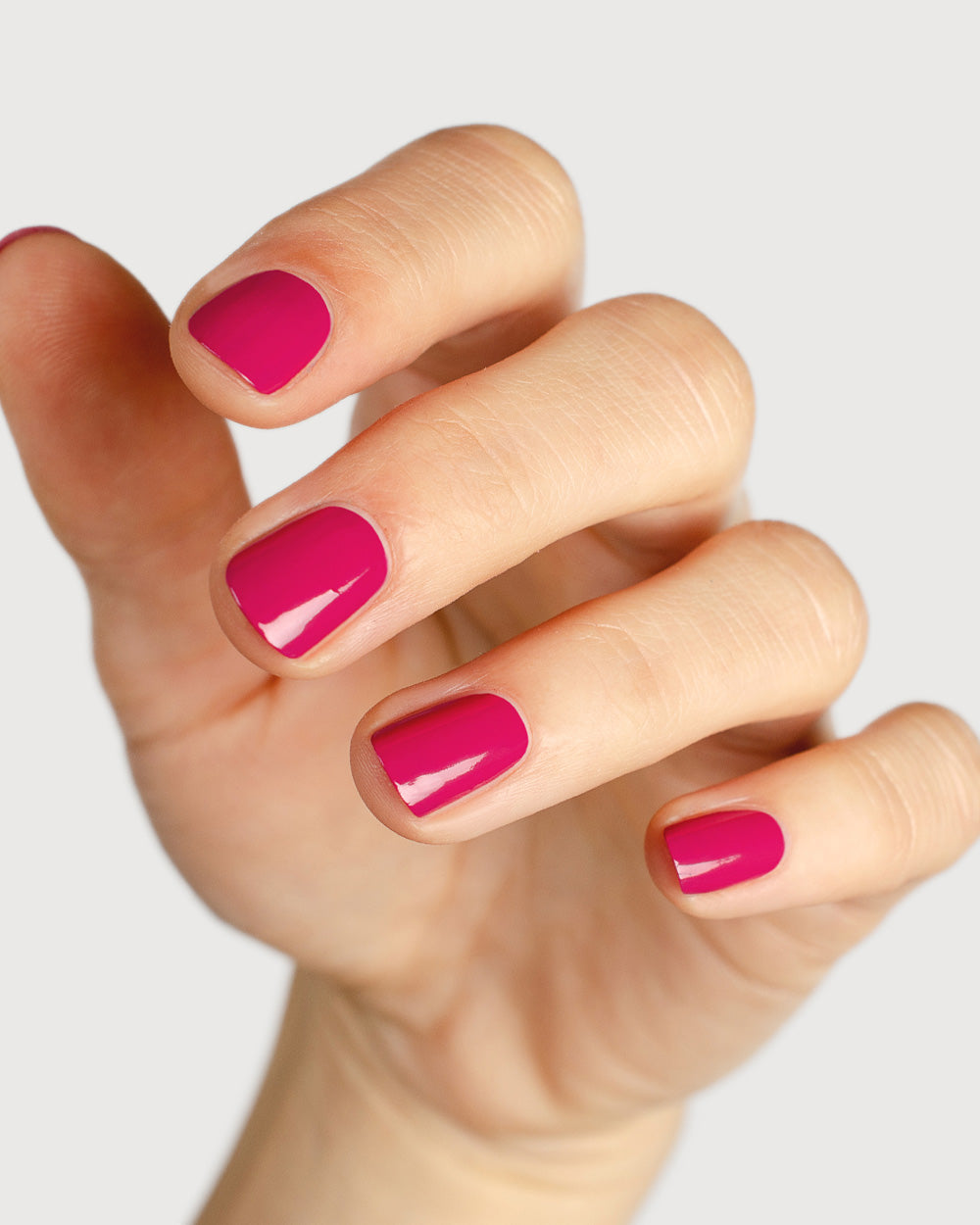 fuschia pink nail polish hand swatch on fair skin tone up close