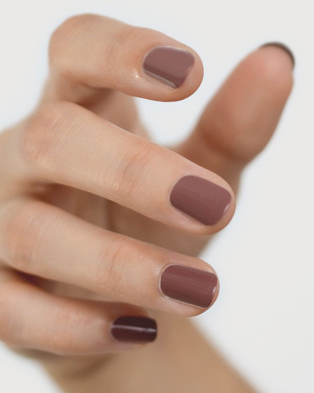 Fair skin hand wearing Grounded mylk chocolate crème nail polish by Sienna Byron Bay close-up