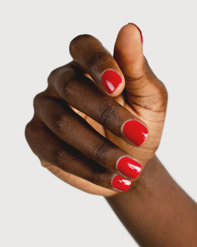classic red nail polish hand swatch on dark skin tone 