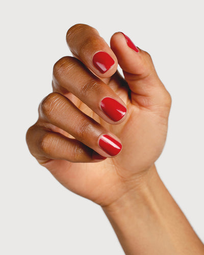 classic red nail polish hand swatch on medium skin tone