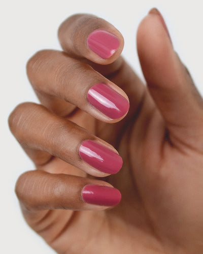 Medium tanned skin hand wearing Heartspace raspberry sorbet nail polish by Sienna Byron Bay close-up
