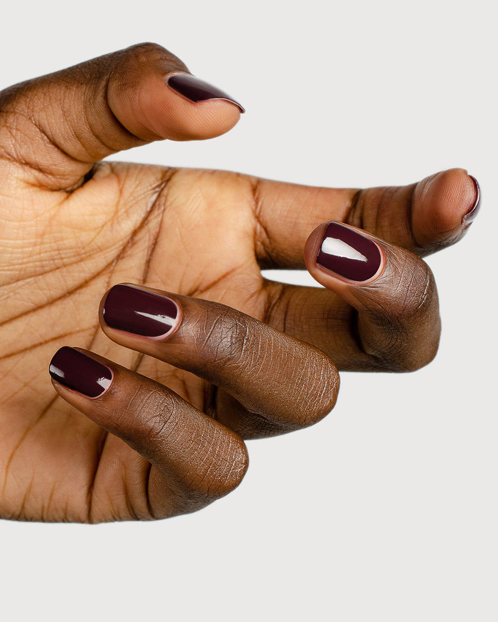 Aubergine nail polish hand swatch on dark skin tone