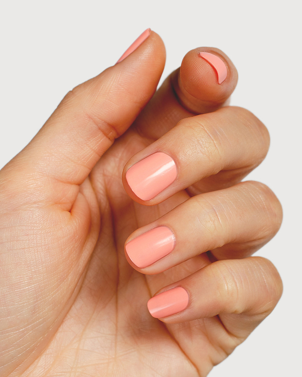 vibrant peach nail polish hand swatch on fair skin tone