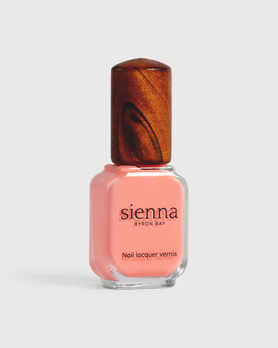 Vibrant peach nail polish glass bottle with timber cap