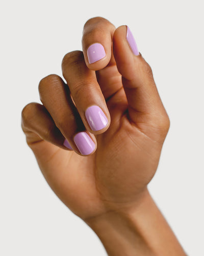 Mid-tone lilac nail polish hand swatch on medium skin tone