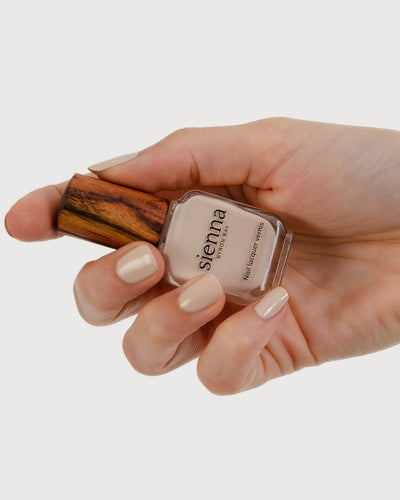 classic beige nail polish hand swatch on fair skin tone holding sienna bottle