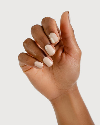 Classic beige nail polish hand swatch on medium skin tone