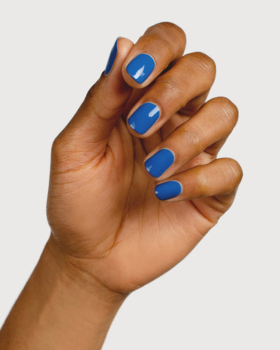 electric blue nail polish hand swatch on medium skin tone