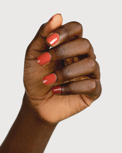 red brick nail polish hand swatch on dark skin tone 