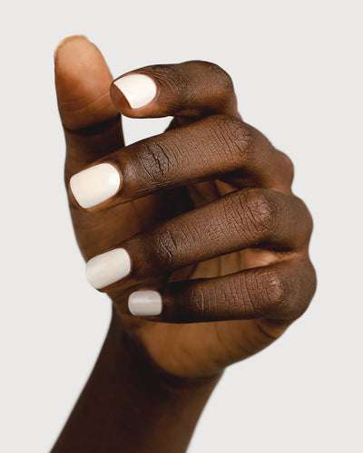 Eggshell white nail polish hand swatch on dark skin tone