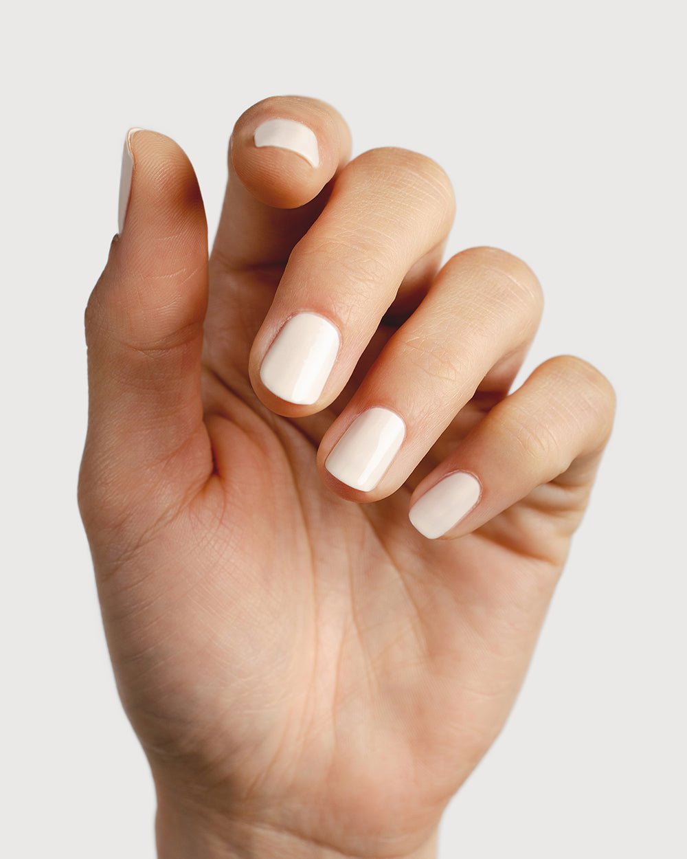 Eggshell white nail polish hand swatch on fair skin tone