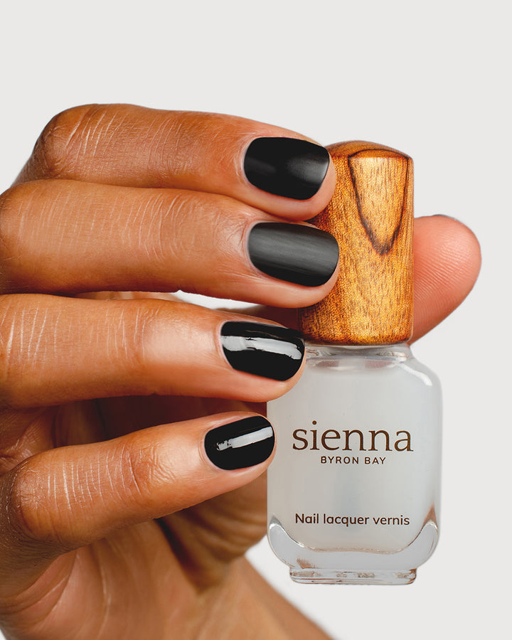 clear matte top coat nail polish hand swatch on medium skin tone holding sienna bottle