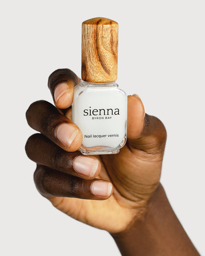 nail strengthener hand swatch on dark skin tone holding sienna bottle