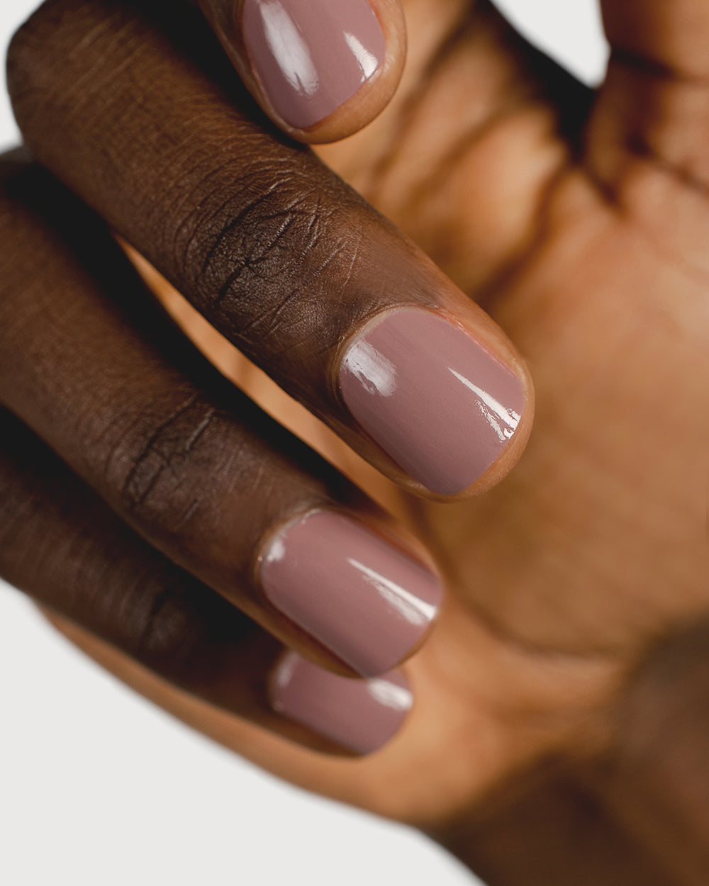 dusty mauve nail polish hand swatch on dark skin tone close up
