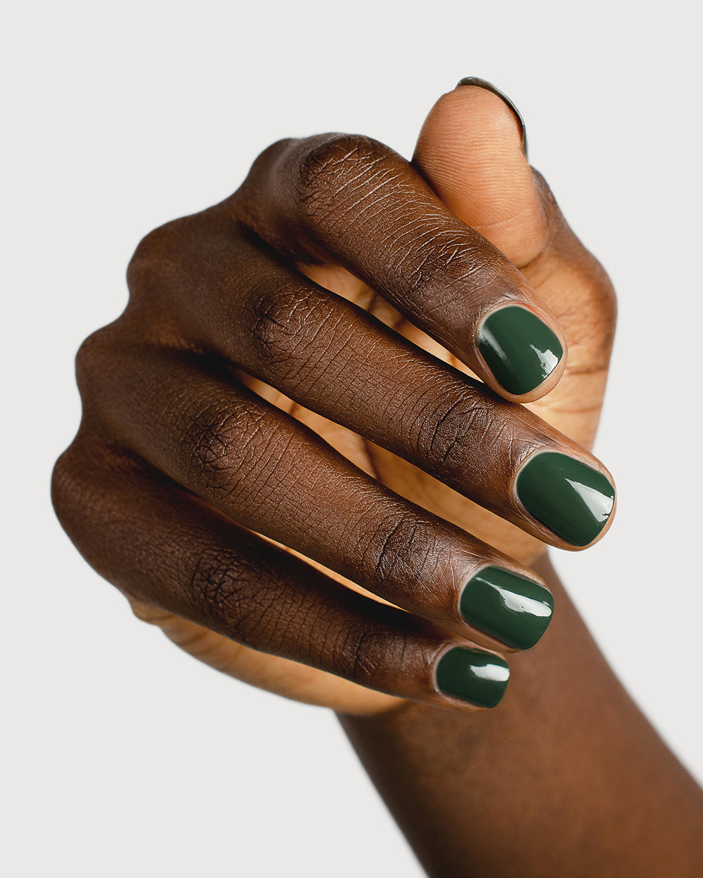 deep olive green nail polish hand swatch on dark skin tone