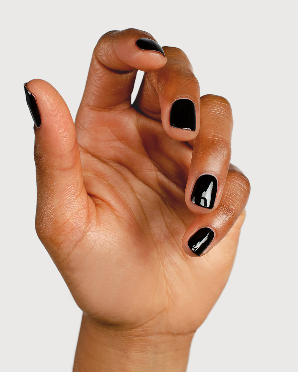 jet black nail polish hand swatch on medium skin tone