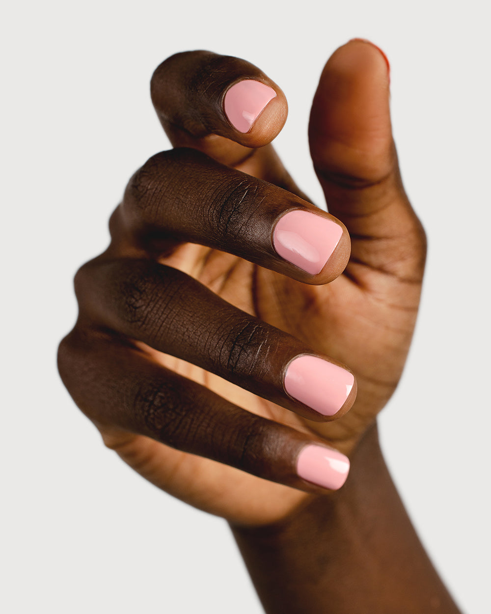 Cherry blossom pink nail polish hand swatch on dark skin tone