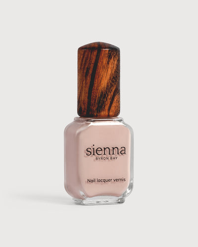 Soft neutral-pink nail polish glass bottle with timber cap