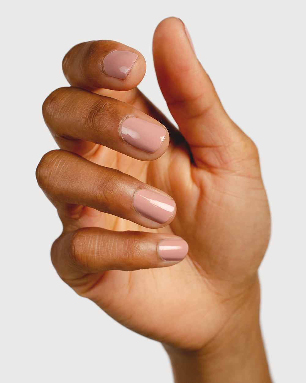 Dusty rose nail polish hand swatch on medium skin tone