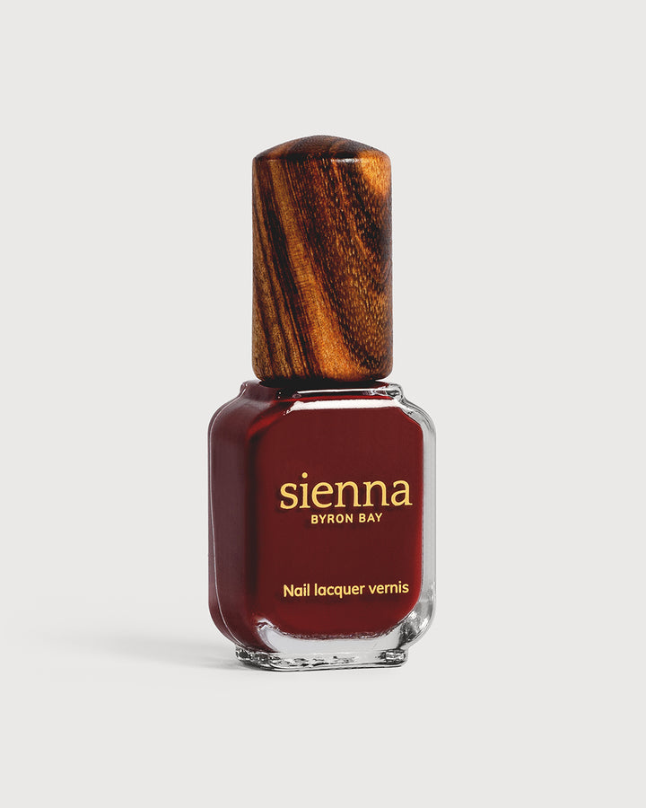 Organic mid-tone red nail polish glass bottle with timber cap
