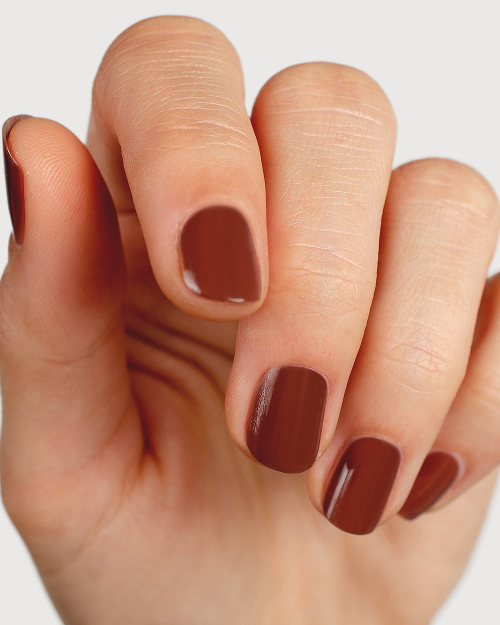brown nail polish hand swatch on fair skin tone