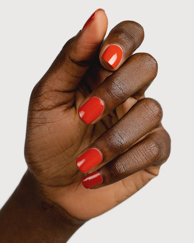 Deep terracotta nail polish hand swatch on dark skin tone
