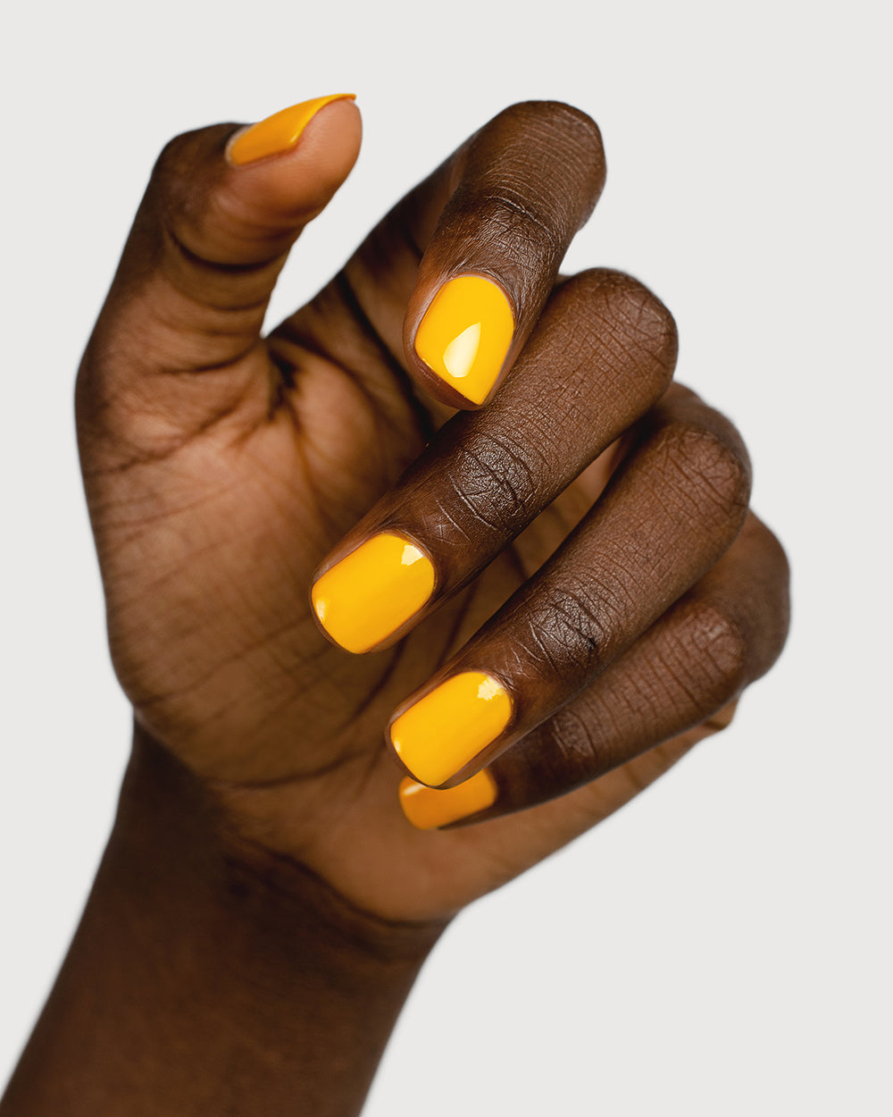 Sunflower yellow nail polish hand swatch on dark skin tone