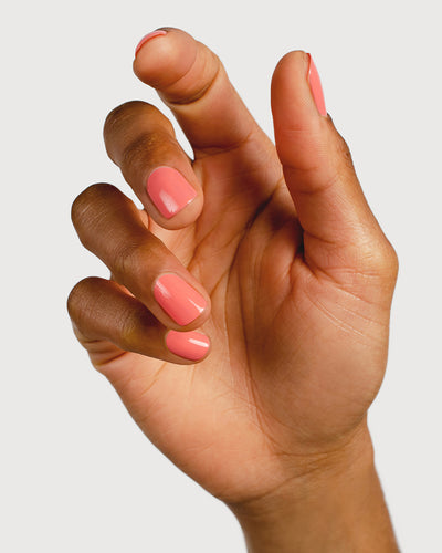 Pink peach nail polish hand swatch on medium skin tone