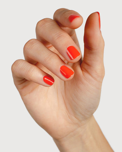 Tangerine nail polish hand swatch on fair skin tone
