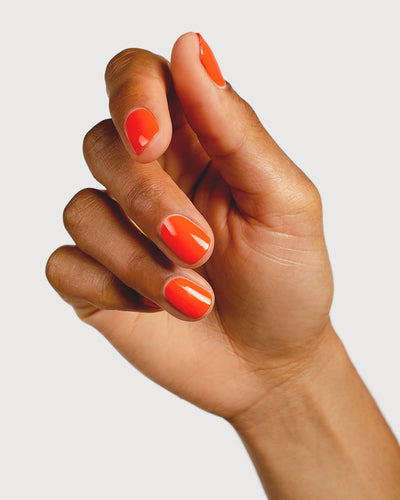 Tangerine nail polish hand swatch on medium skin tone
