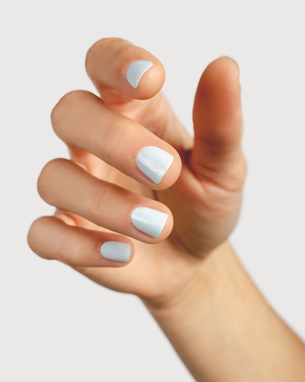 Pastel blue nail polish hand swatch on fair skin tone