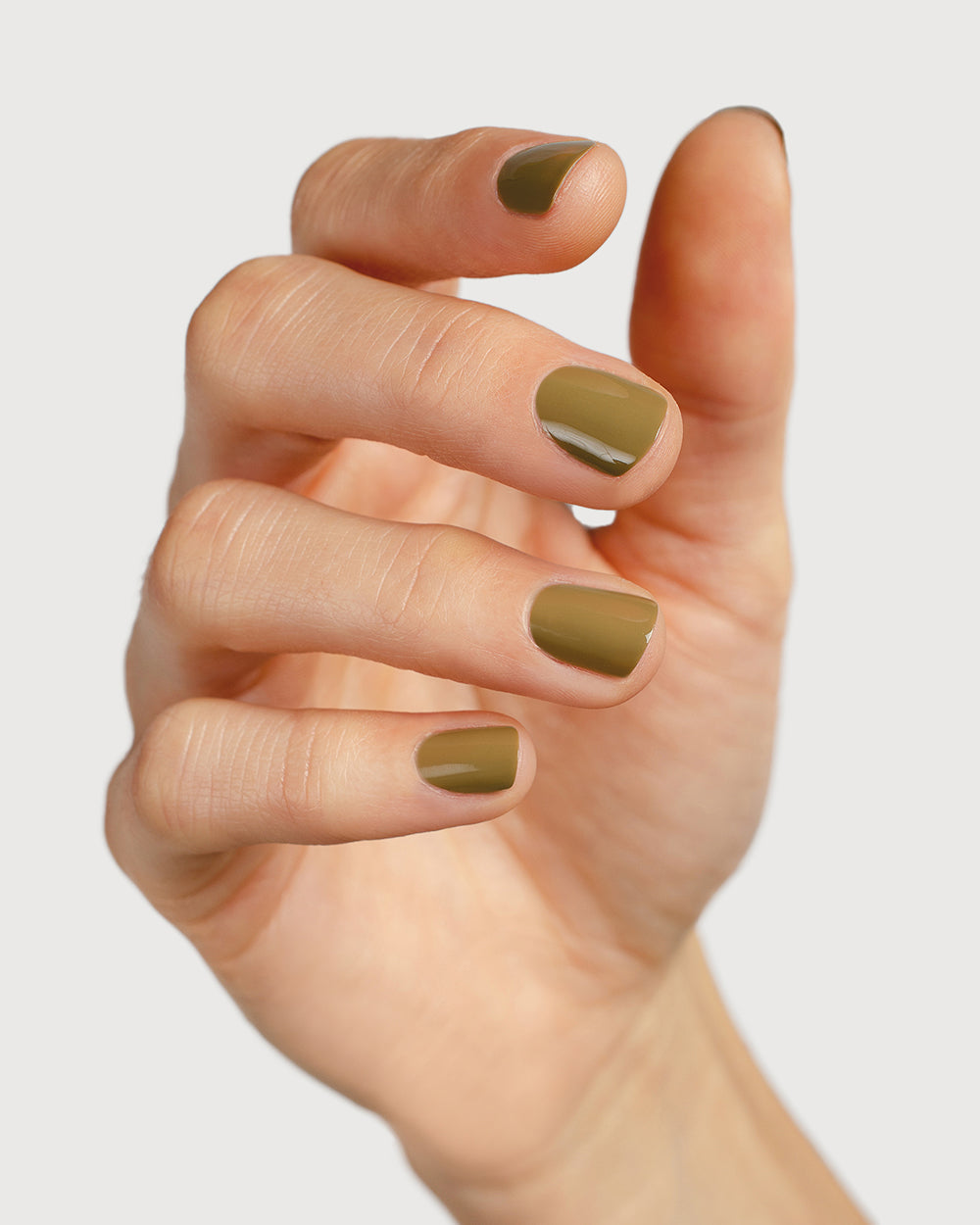 Khaki green nail polish hand swatch on fair skin tone