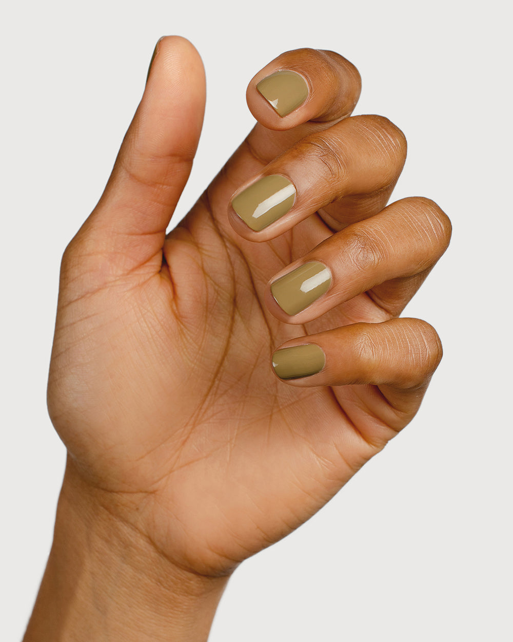 Khaki green nail polish hand swatch on medium skin tone
