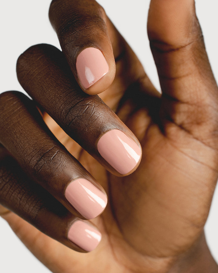 Dusty rose nail polish hand swatch on dark skin tone up-close